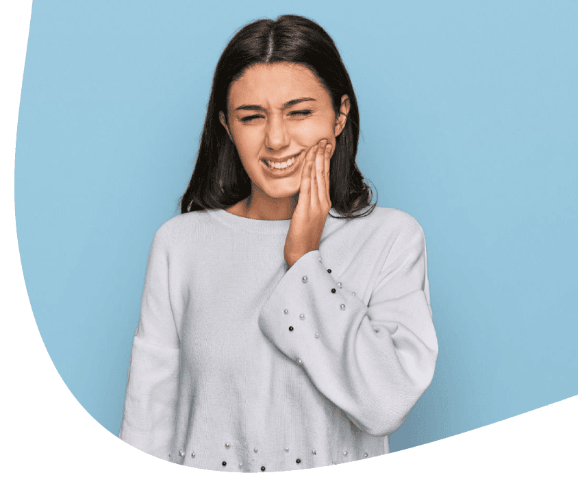 Žena držící tvář v bolesti, naznačuje problém se zubem