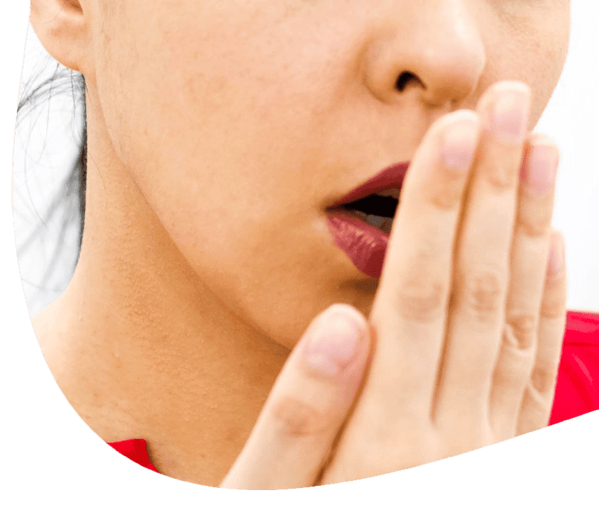 Detail osoby, která drží ruku před ústy, kontroluje dech